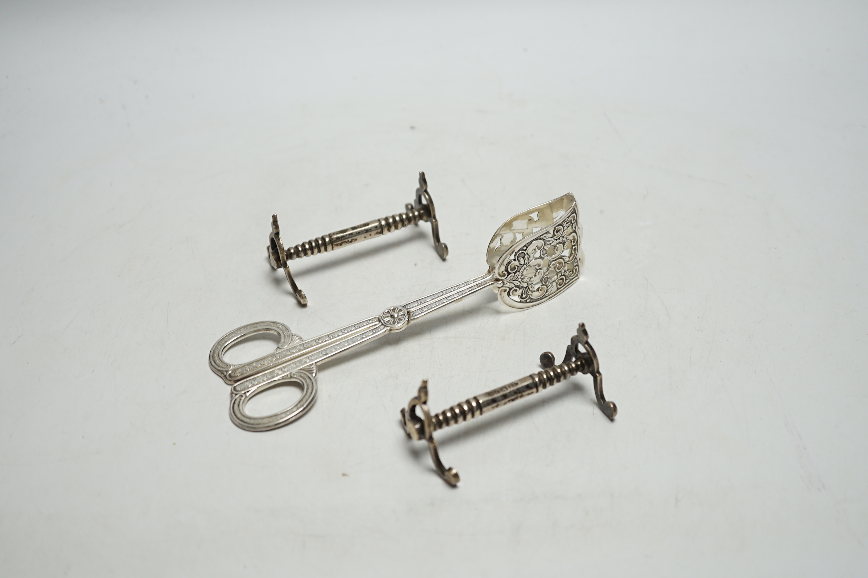 A pair of Swedish metal asparagus tongs and a pair of Edwardian silver knife rests, London, 1909.16.6cm